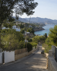 Hillside villas, green mountains and a rocky cove in Costa Blanca North