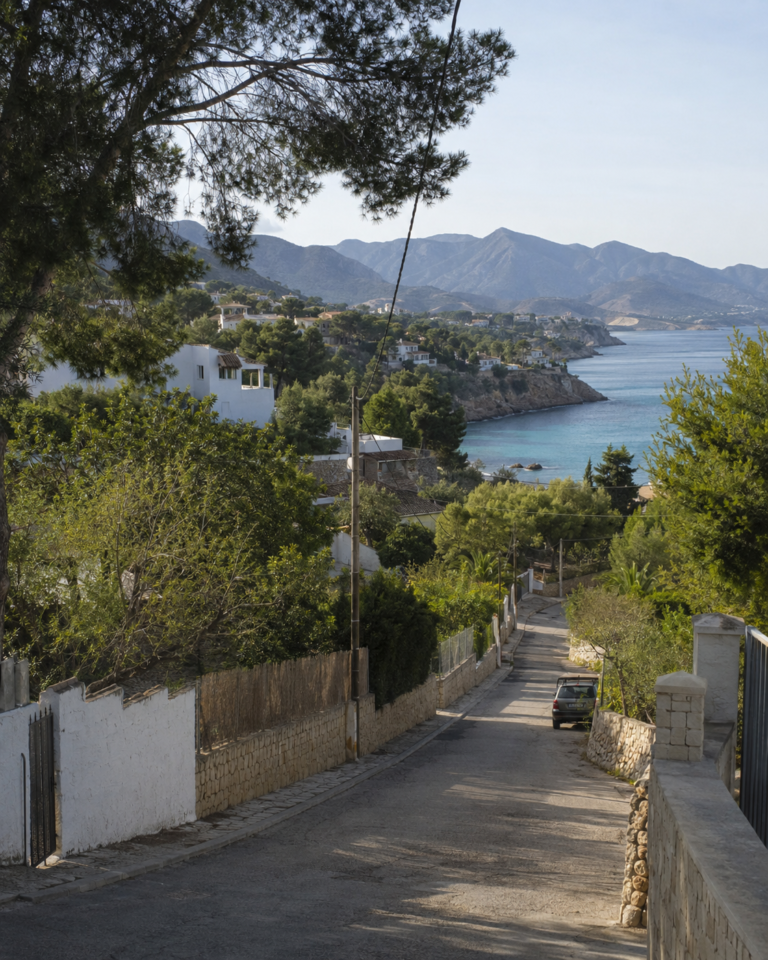 Hillside villas, green mountains and a rocky cove in Costa Blanca North